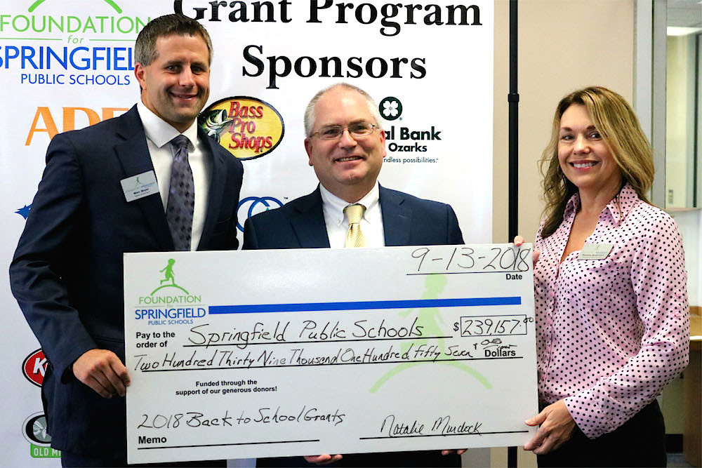 Foundation for SPS board President-elect Marc Mayer, left, and Foundation for SPS Director of Development Pamela Anderson, right, present a check for $239,157 in grants to SPS Chief Learning Officer Mike Dawson.